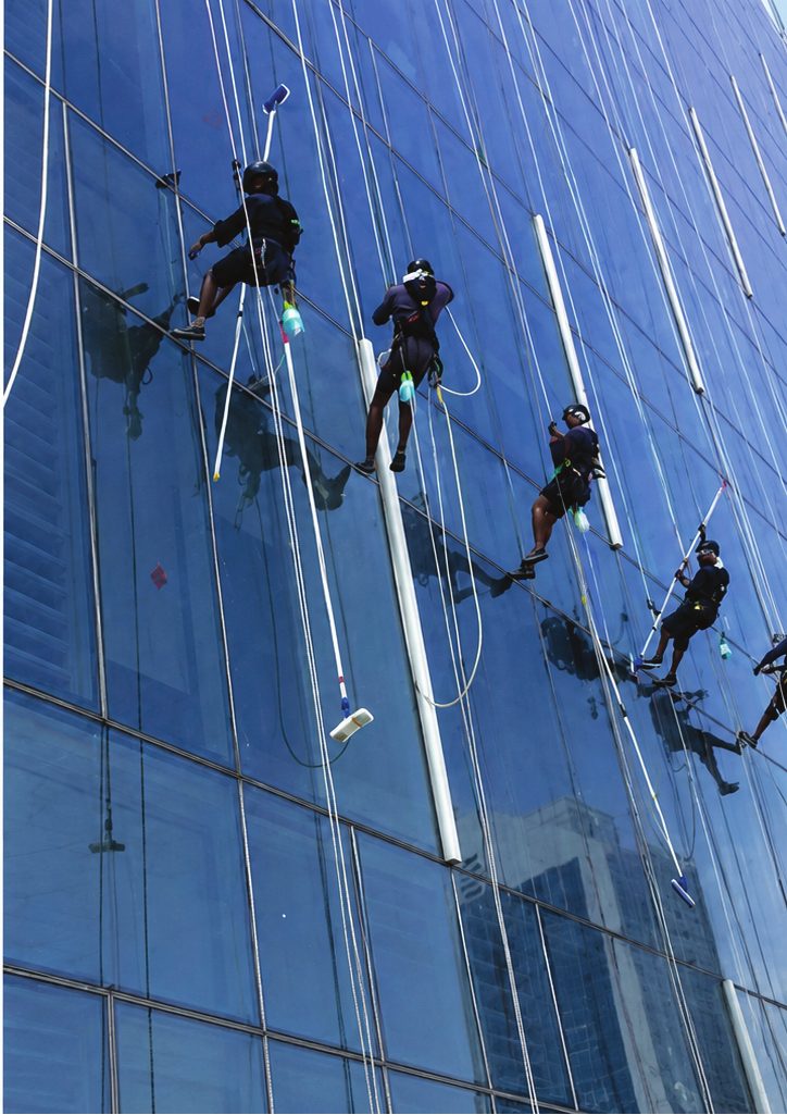 Rope-access technicians cleaning a glass high-rise facade